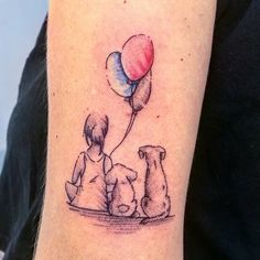 a person with a dog and balloon tattoo on their arm