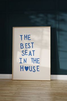 the best seat in the house print is displayed on a wooden floor next to a blue wall