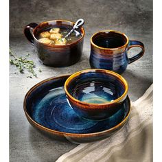 two bowls with spoons are sitting next to each other on a table, one is filled with soup