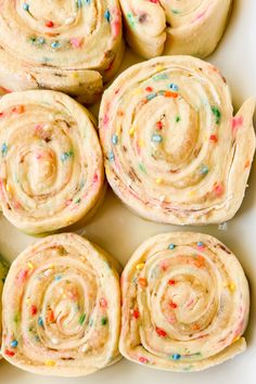 several rolls with colorful sprinkles in a white dish