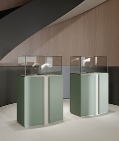 two glass cases sitting on top of a white floor