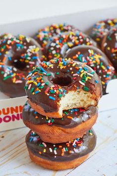 chocolate donuts with sprinkles stacked on top of each other