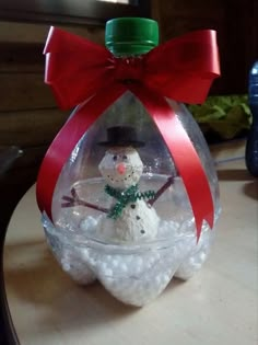 a snowman in a glass ornament on a table