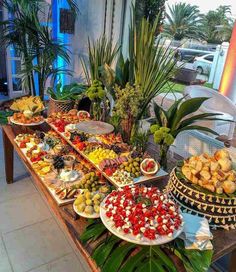 a buffet table filled with lots of different types of food on plates and trays