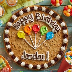 a birthday cake with the words jordan on it surrounded by desserts and candies