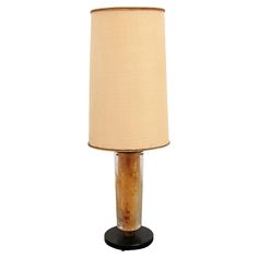 a table lamp with a beige shade on it's base and a black base