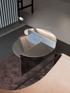 a modern coffee table sitting on top of a carpeted floor next to a radiator