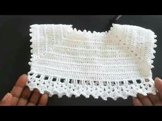 someone is holding a piece of white crocheted material