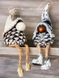 two pine cone ornaments are hanging on a shelf