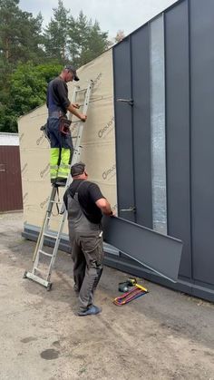 two men working on the side of a building