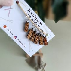 a pair of handmade wooden earrings on top of a card next to a plant