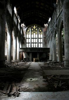 an abandoned church with stained glass windows and debris on the floor