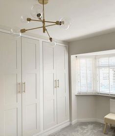 an empty room with white cabinets and a bench