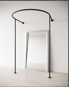 a white room with an open door and a black pole in the corner that has a mirror on it