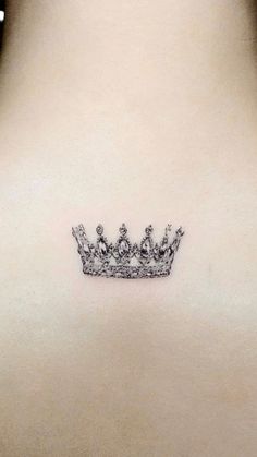 a crown tattoo on the back of a woman's neck