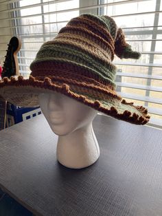 a hat is sitting on top of a mannequin's head in front of a window