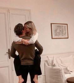 a man and woman hug each other in the living room