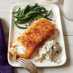 a white plate topped with fish and green beans