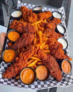 fried chicken and french fries with dipping sauces on a checkerboard platter