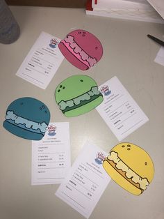 four different colored hamburgers on top of a table with paper tags attached to them