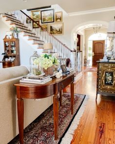 a living room filled with furniture and a stair case in front of a staircase leading up to the second floor