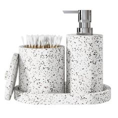 a white toilet paper holder with toothbrushes and soap dispenser in it