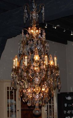 a chandelier hanging from the ceiling in a room with many lights on it