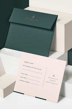 three different colored envelopes on top of each other, one with a card in the middle