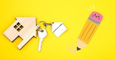 a wooden house keychain with a pencil on it next to a pair of keys