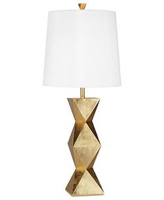 a lamp that is sitting on top of a table next to a white lamp shade