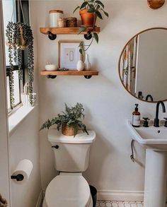 a white toilet sitting under a bathroom mirror next to a sink and bathtub in a bathroom