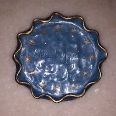 a decorative blue plate with gold stars on it and the word love spelled in cursive writing