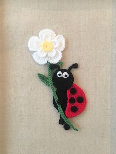 a crocheted ladybug with a flower on it's back is shown