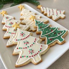 decorated christmas tree cookies on a white plate