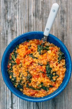 a blue bowl filled with food on top of a wooden table