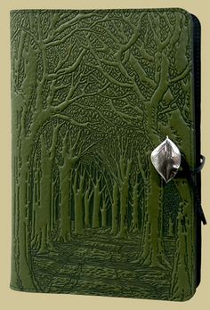 a green leather journal with trees on it