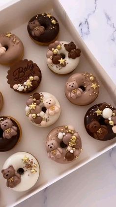 a box filled with lots of donuts covered in frosting and teddy bear decorations