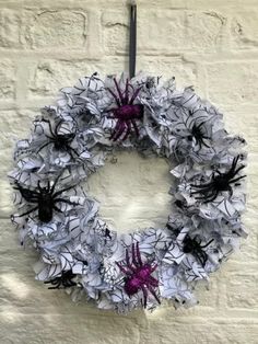 a wreath hanging on the side of a building with spider webs attached to it