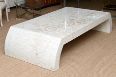 a white marble coffee table sitting on top of a carpeted floor