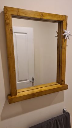 a mirror hanging on the wall above a towel rack