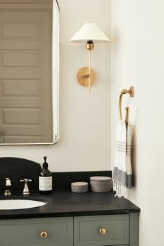 a bathroom with a sink, mirror and towel rack