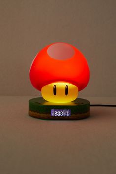 an alarm clock with a mushroom light on it's face is shown in front of a gray background