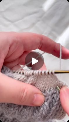 someone is crocheting the stitchs on a knitted object with a needle