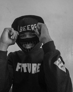 a young boy wearing a hoodie with the word future painted on it's face