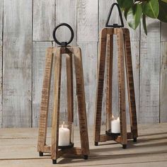 two wooden lantern holders with candles on them