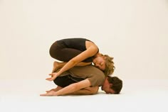 a man and woman are doing yoga on the floor together in front of a white background