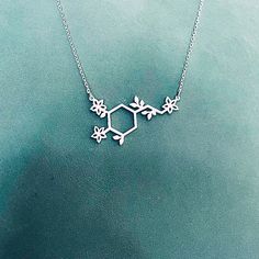 "Sterling Silver Dopamine Necklace with tiny leaves and flowers. Dopamine Molecule represents the passion and the devotion in our lives. This necklace is a great way to let others know how happy they make you! ✅ PRODUCT DETAILS * Material: solid sterling silver. * Pendant is 1.3mm thick. * The total length is the chain length only, it does not include the length of the charm. * All necklaces come with a 2\" extender for adjustable length. ✅ PRODUCTION & SHIPPING INFO 📌 Important: please be Dopamine Necklace, Dopamine Jewelry, Science Necklace, Molecule Jewelry, Science Christmas, Chemistry Necklace, Dopamine Molecule, Chemistry Jewelry, Molecule Necklace