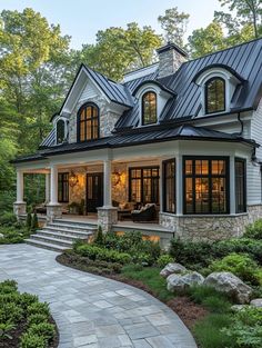 a large white house with lots of windows and stone steps leading up to the front door