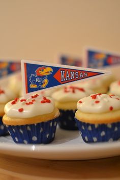 cupcakes with white frosting and red sprinkles on a plate