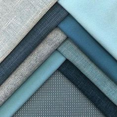 several different colors of fabric on top of each other, including light blue and grey